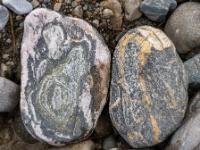 Grauweißer Stein mit erhabenem Muster neben grauem Stein mit Ockermaserung